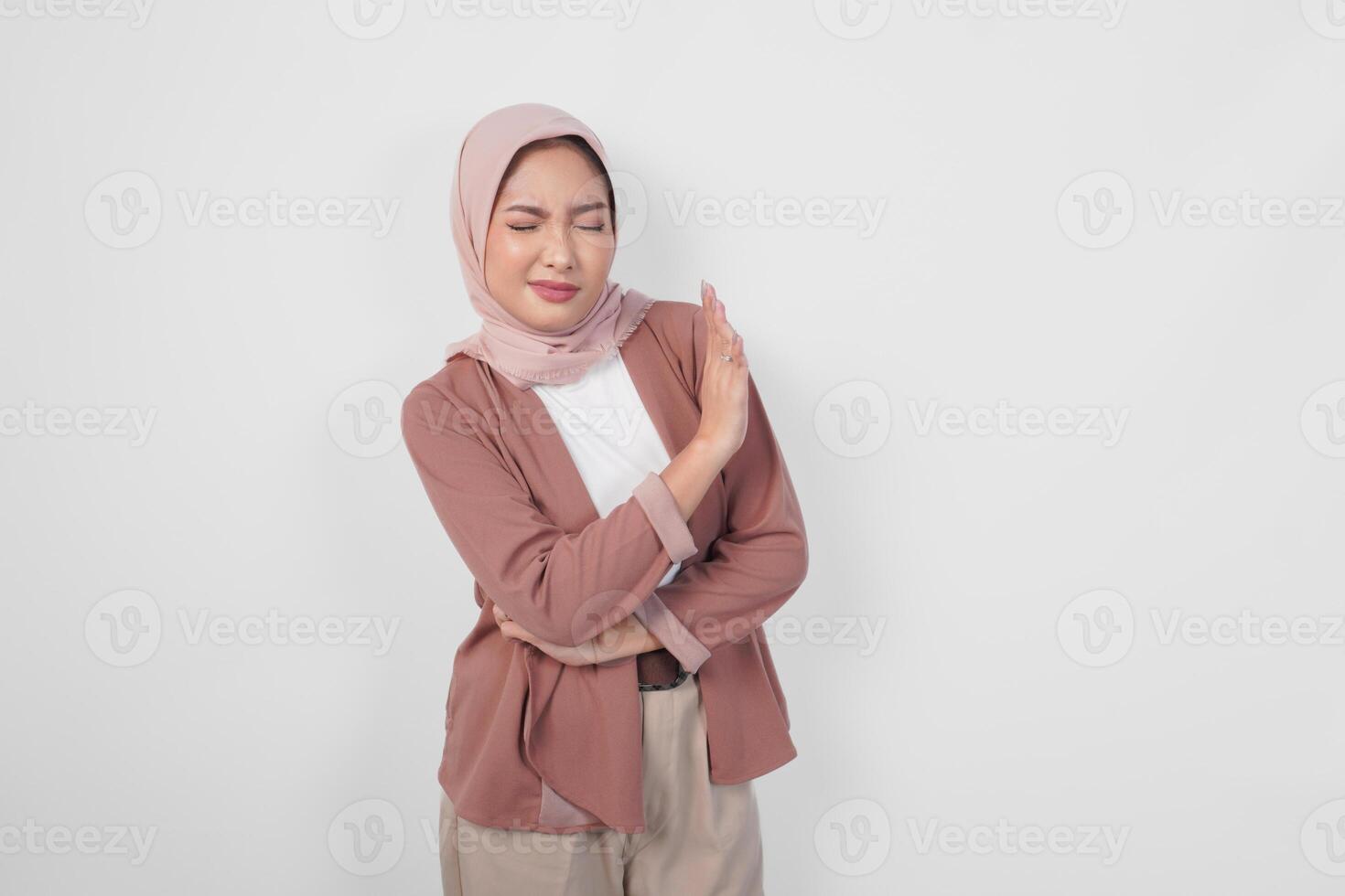 Young Asian Muslim woman wearing a hijab gesturing rejection or decline pose with copy space. photo