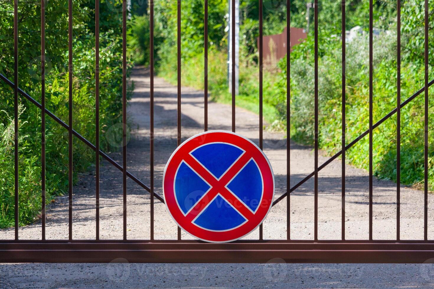 sign parking is prohibited on the metal gate on a background of the park photo