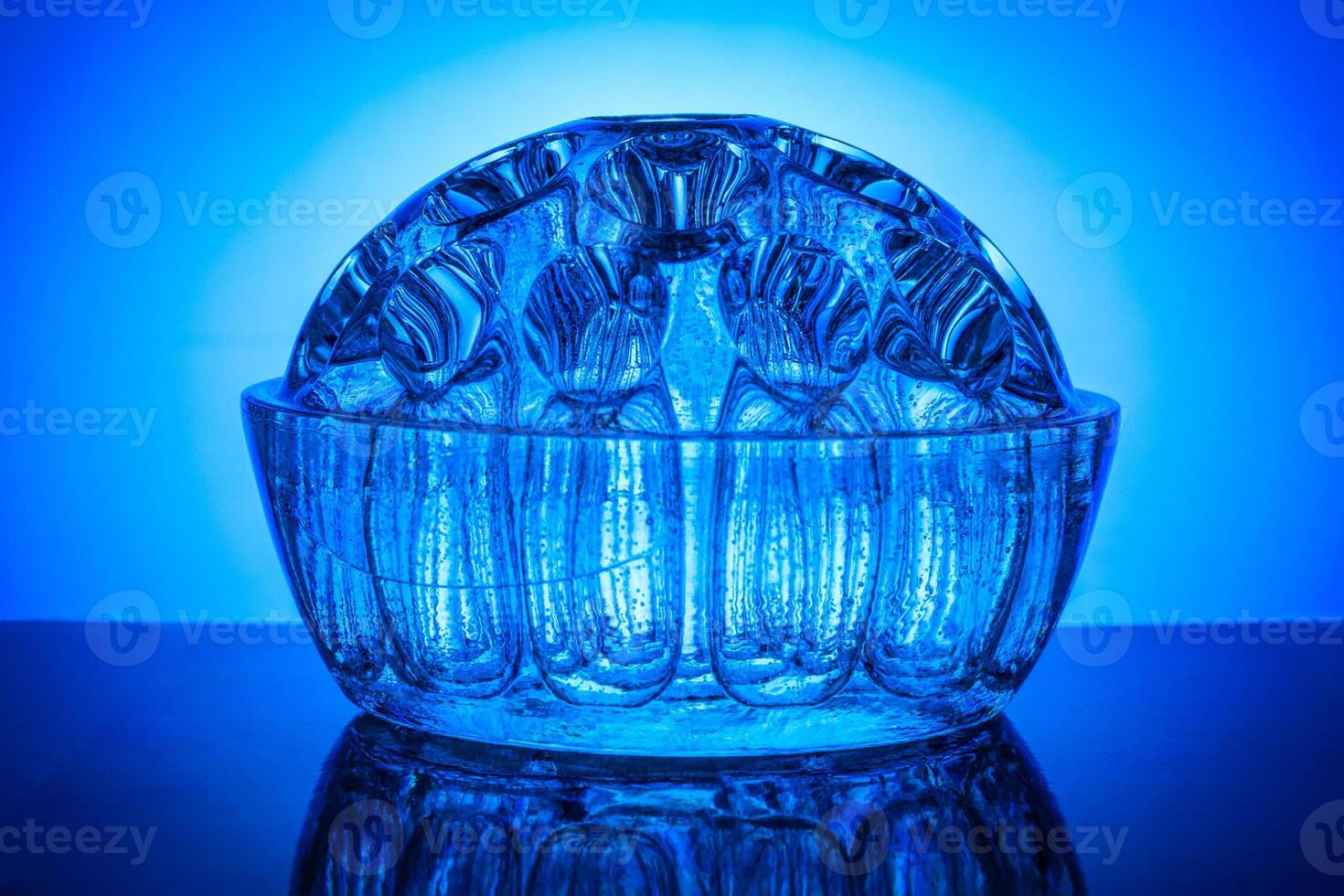 Decorative semicircular glass vase on a background of blue gradient photo