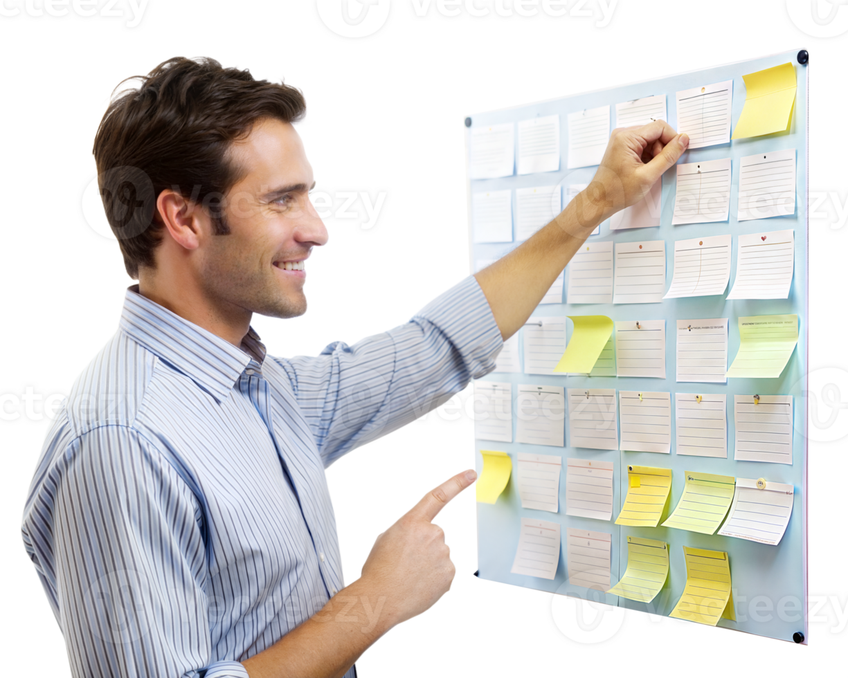 A young man arranges sticky notes on a board with a content smile, likely brainstorming or planning steps for a project png