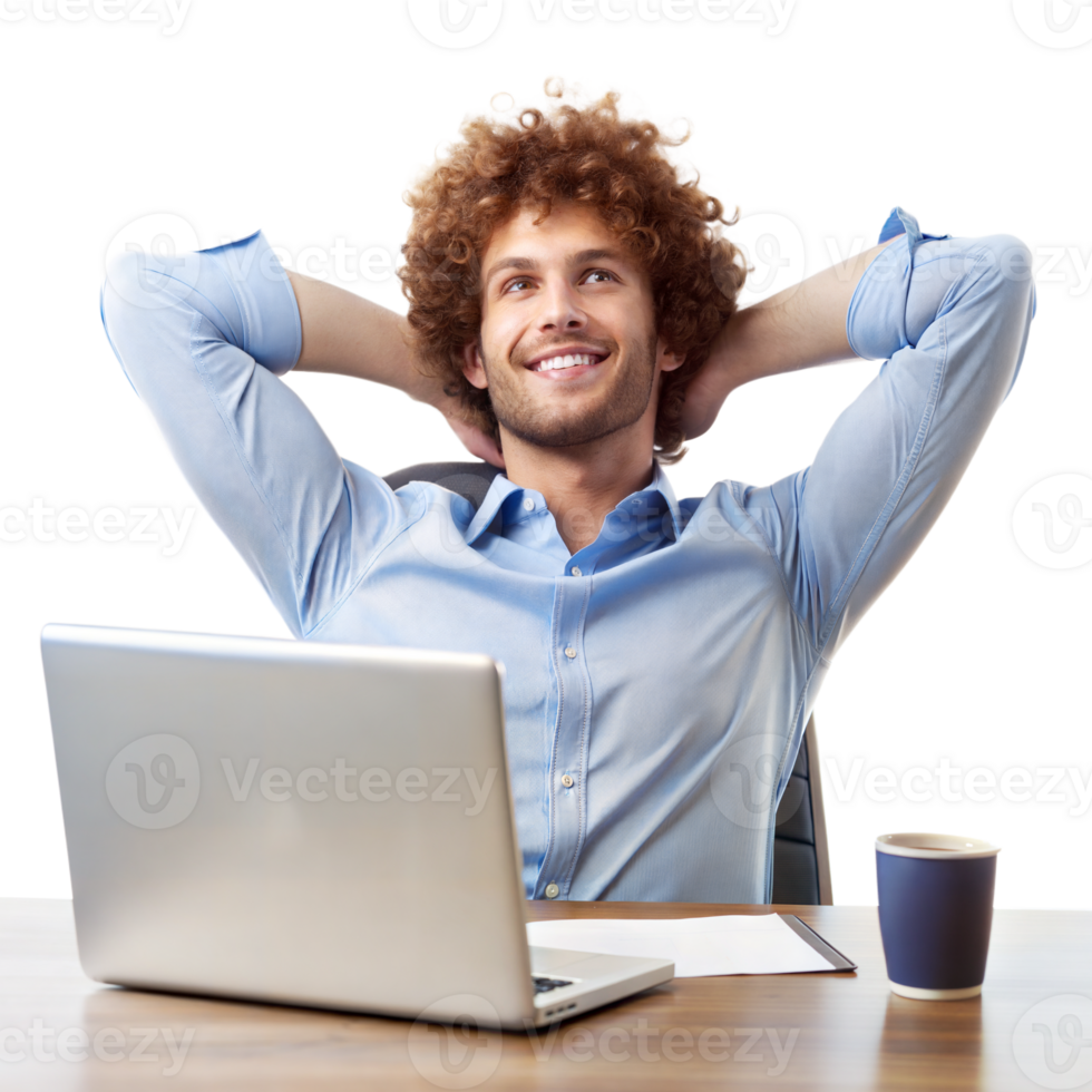 A smiling man with curly hair leans back in his chair, hands behind head, next to a laptop and coffee cup png