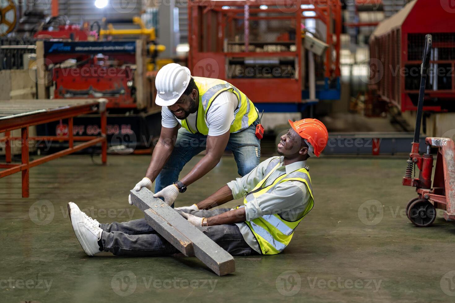 African American factory worker having accident while working in manufacturing site while his colleague is helping for safety workplace and emergency photo