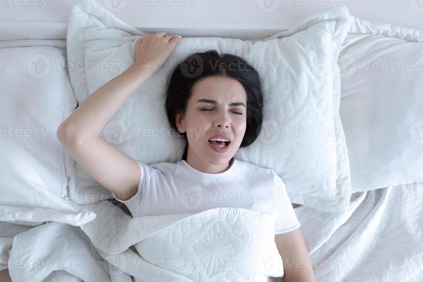 A beautiful woman lies in bed, enjoys an orgasm, alone at home. photo