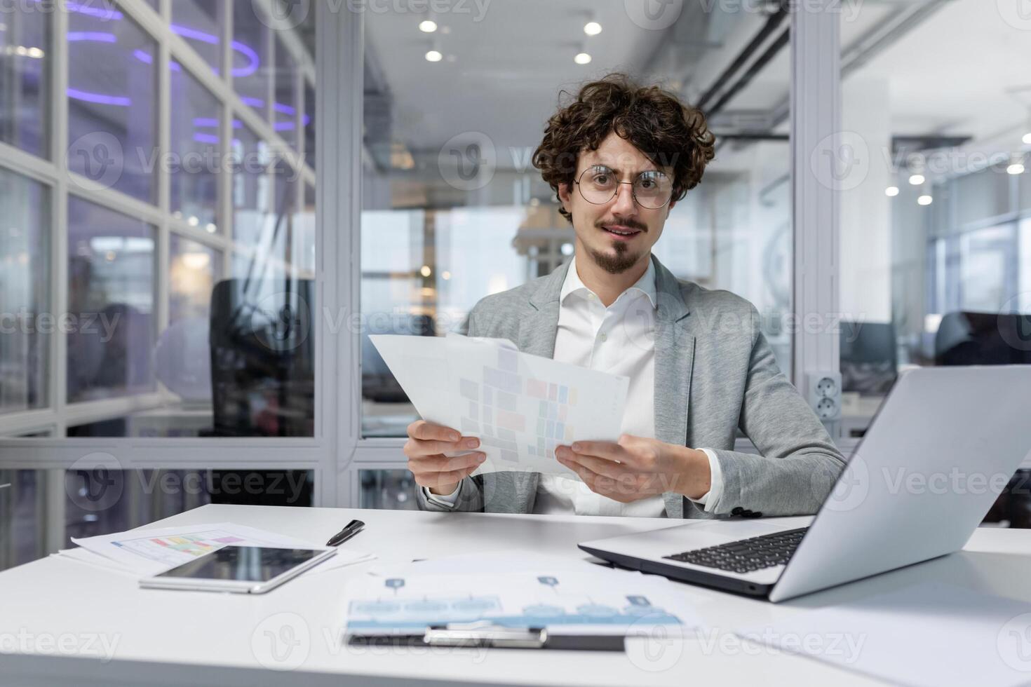 Portrait of successful financier at work at workplace inside office, mature man smiling and looking at camera, businessman in shirt working with documents graphs and charts, paperwork using laptop photo