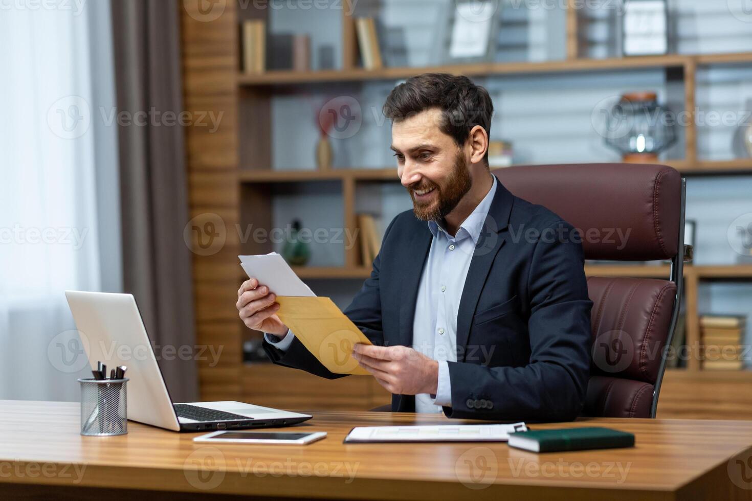Happy successful boss received mail notification envelope with good news message, financier at workplace inside office, businessman happy with successful delivery results. photo