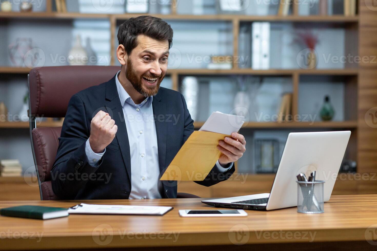 Happy successful boss received mail notification envelope with good news message, financier at workplace inside office, businessman happy with successful delivery results. photo