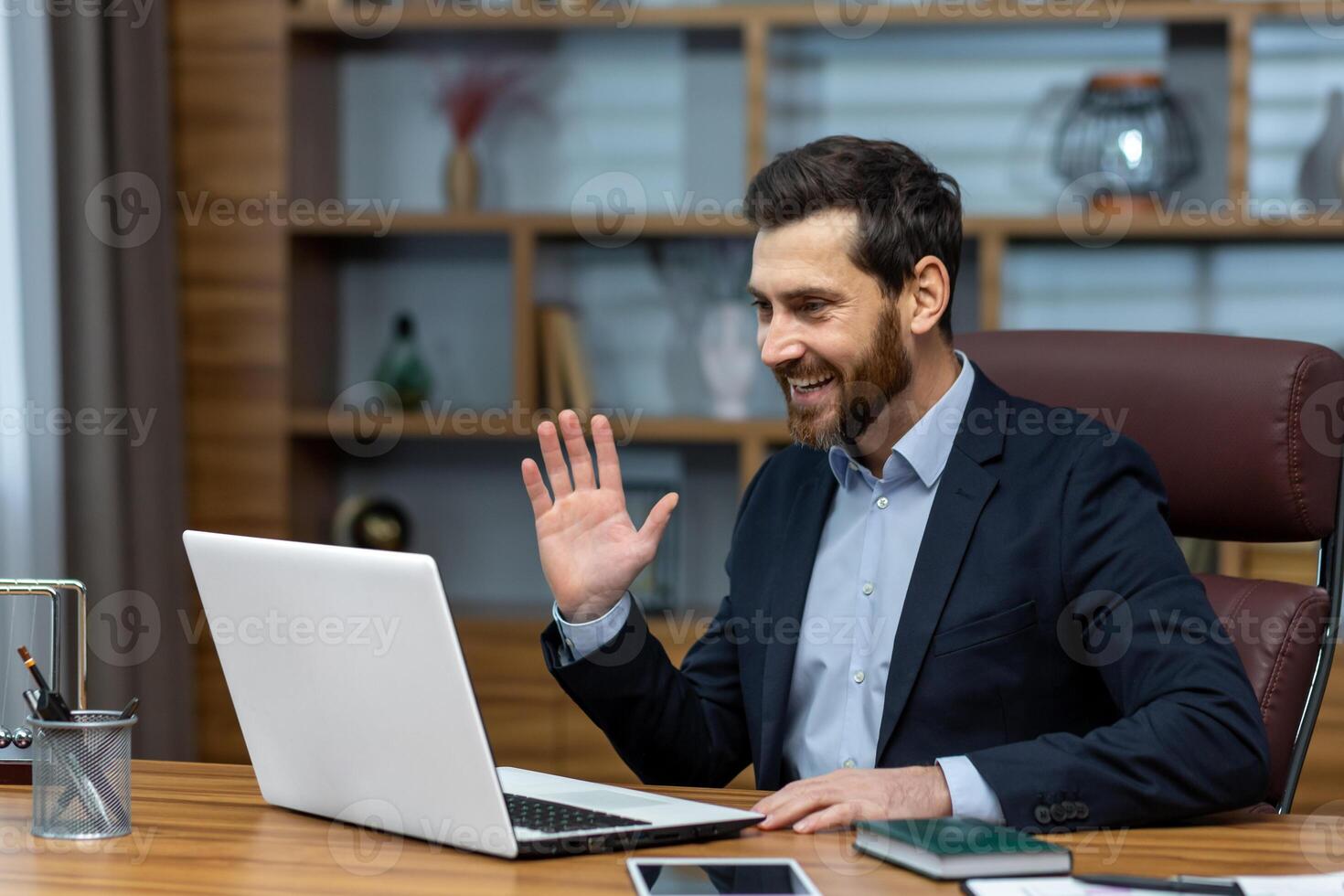 Online meeting, mature businessman inside office talking remotely online with colleagues and partners, call senior male executive using laptop to communicate photo