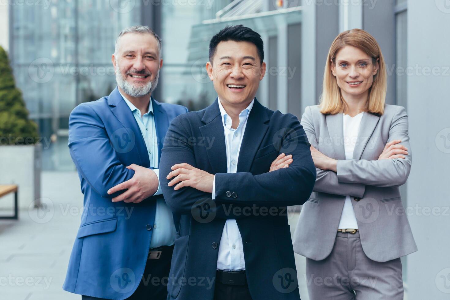 Business team, male and female colleagues in business attire looking at camera and smiling with arms crossed photo