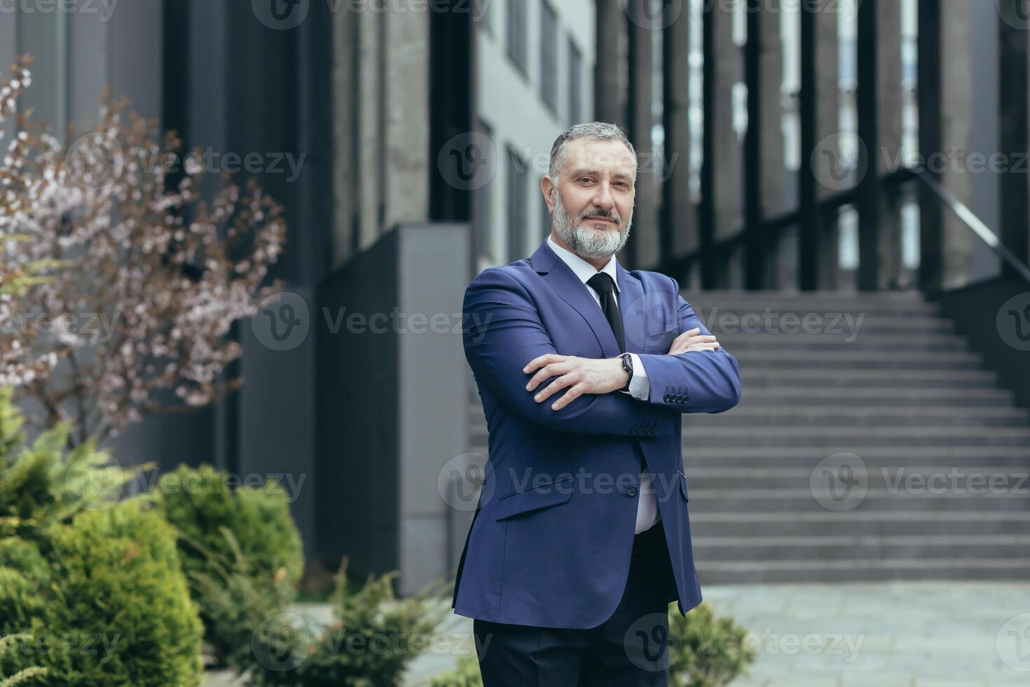 Portrait of successful director and business owner, man with crossed arms smiling outside office building, businessman investor in business suit confident photo