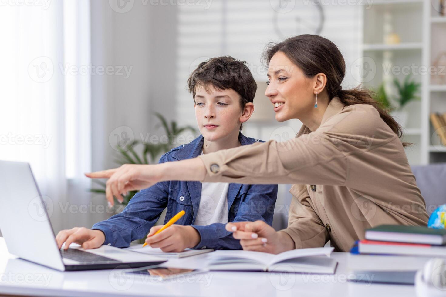 Mother and son studying together sitting at desk at home in living room, boy and woman tutor teaching at home, doing homework together. photo
