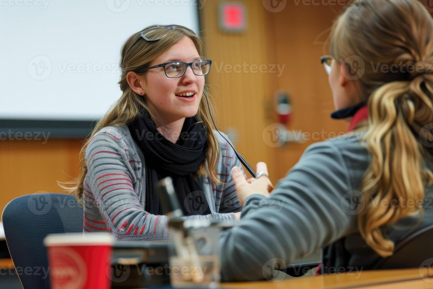 A picture of a hearing-impaired student using a sign language interpreter during a lecture, emphasizing the provision of communication support to facilitate effective learning. photo
