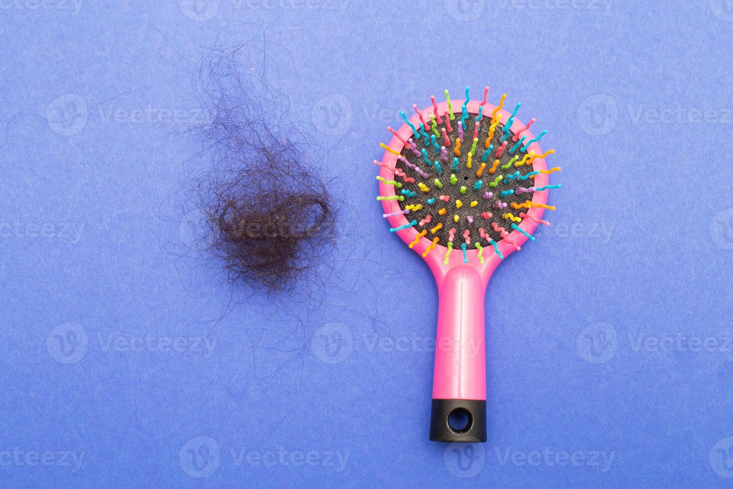 Hair loss a plastic multicolored comb on a paper blue background with copy space close up. photo