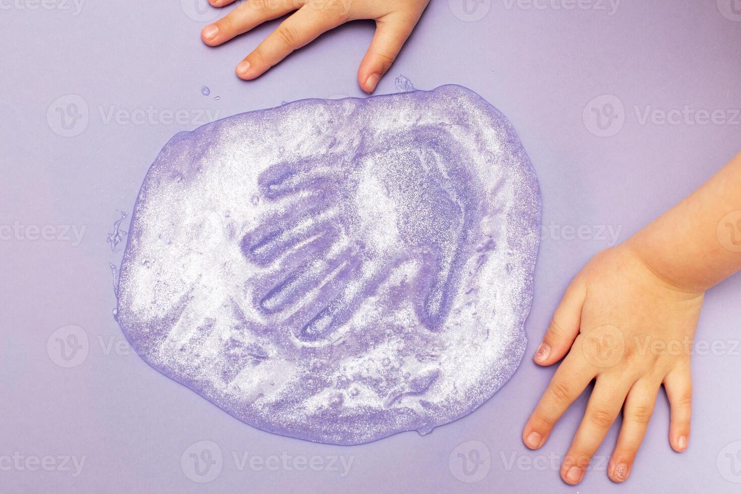 child playing with a slime at home. kid stretching colorful slime. DIY concept. photo