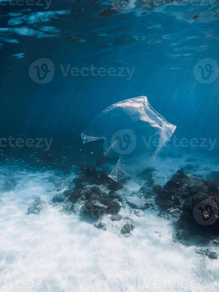 Underwater view in transparent ocean with plastic bag and rubbish, ecological problem photo