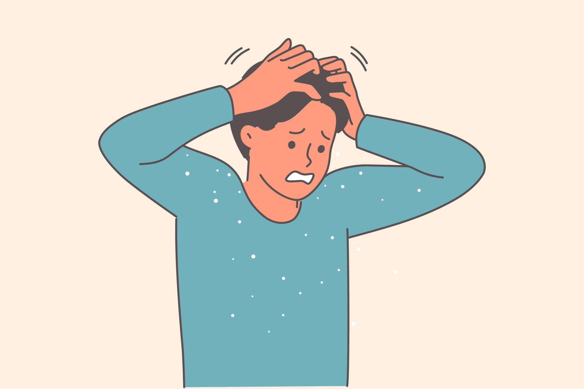 Dandruff falls from hair of man scratching head due to itching caused