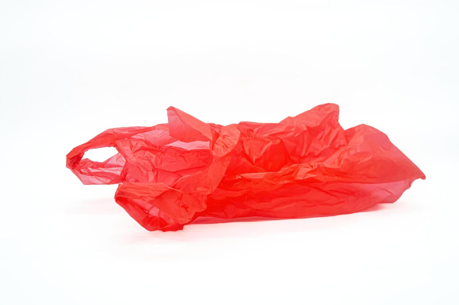 Red plastic bag crumpled on white background. Copy space photo