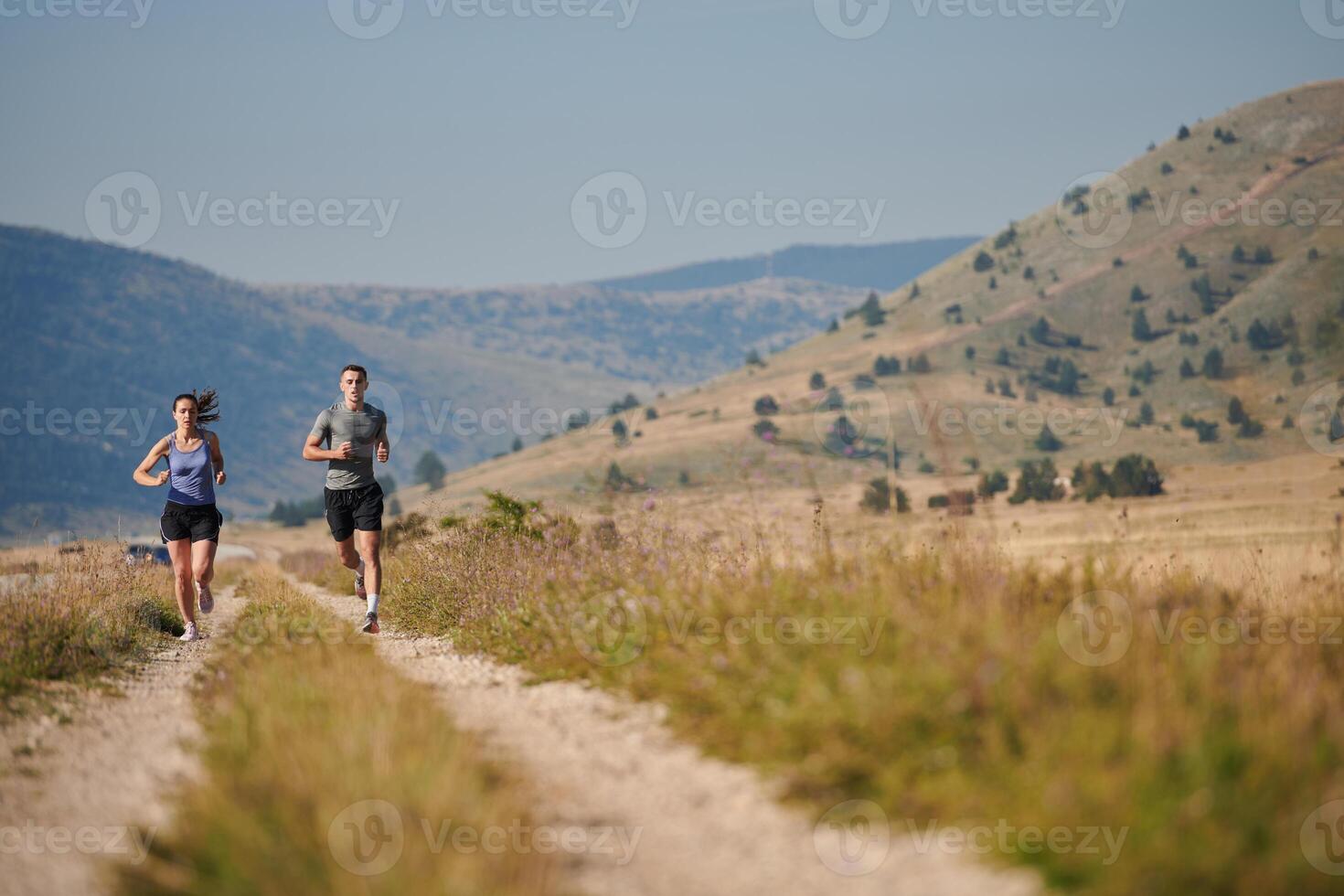 Energized by the beauty of nature, a couple powers through their morning run, their bodies and spirits invigorated. photo