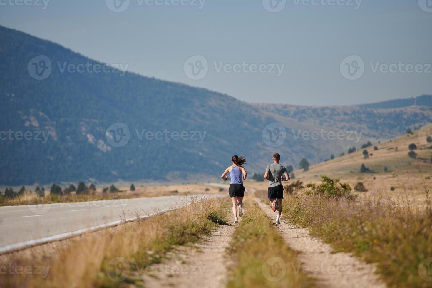 Energized by the beauty of nature, a couple powers through their morning run, their bodies and spirits invigorated. photo