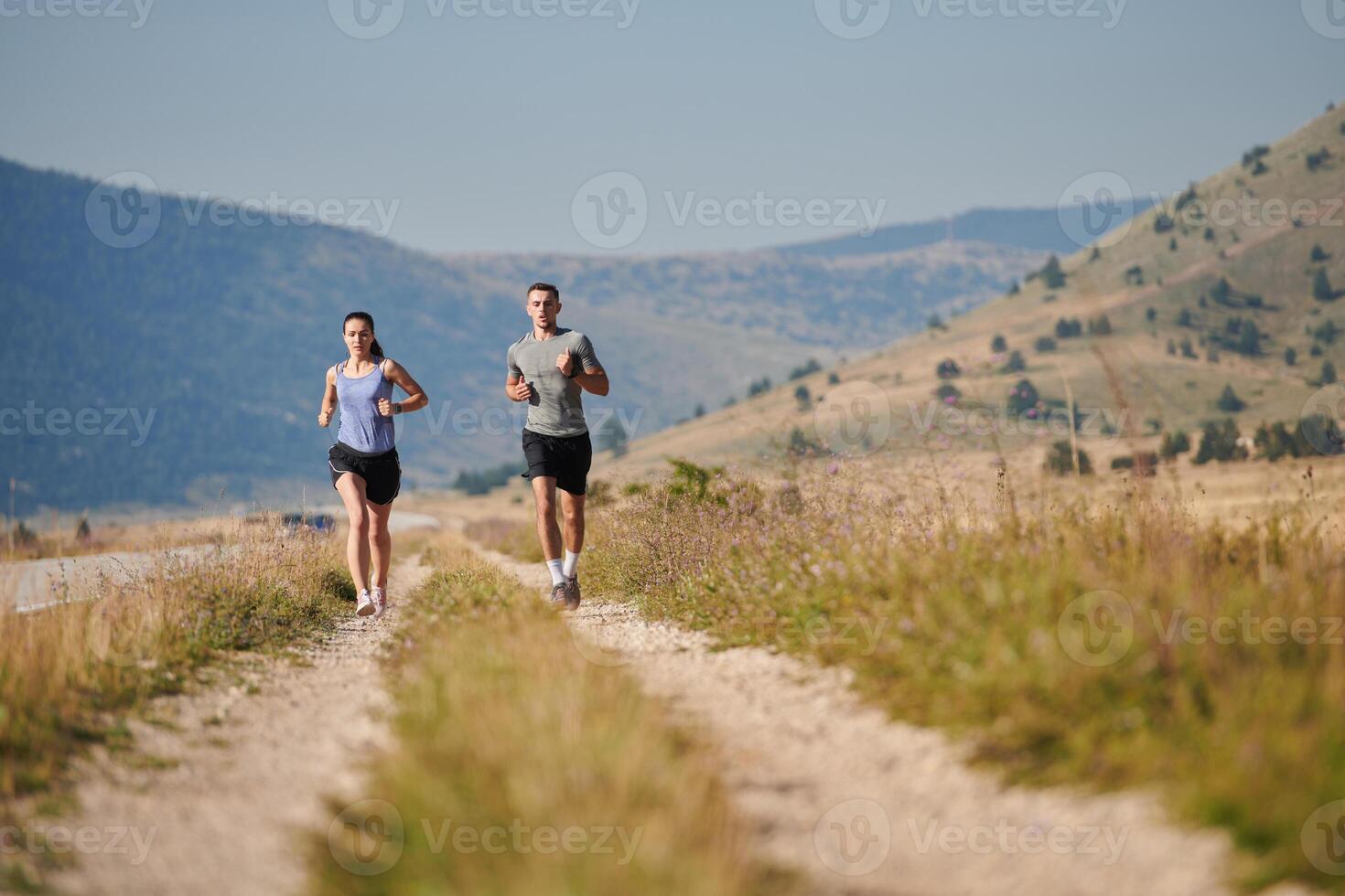 Energized by the beauty of nature, a couple powers through their morning run, their bodies and spirits invigorated. photo