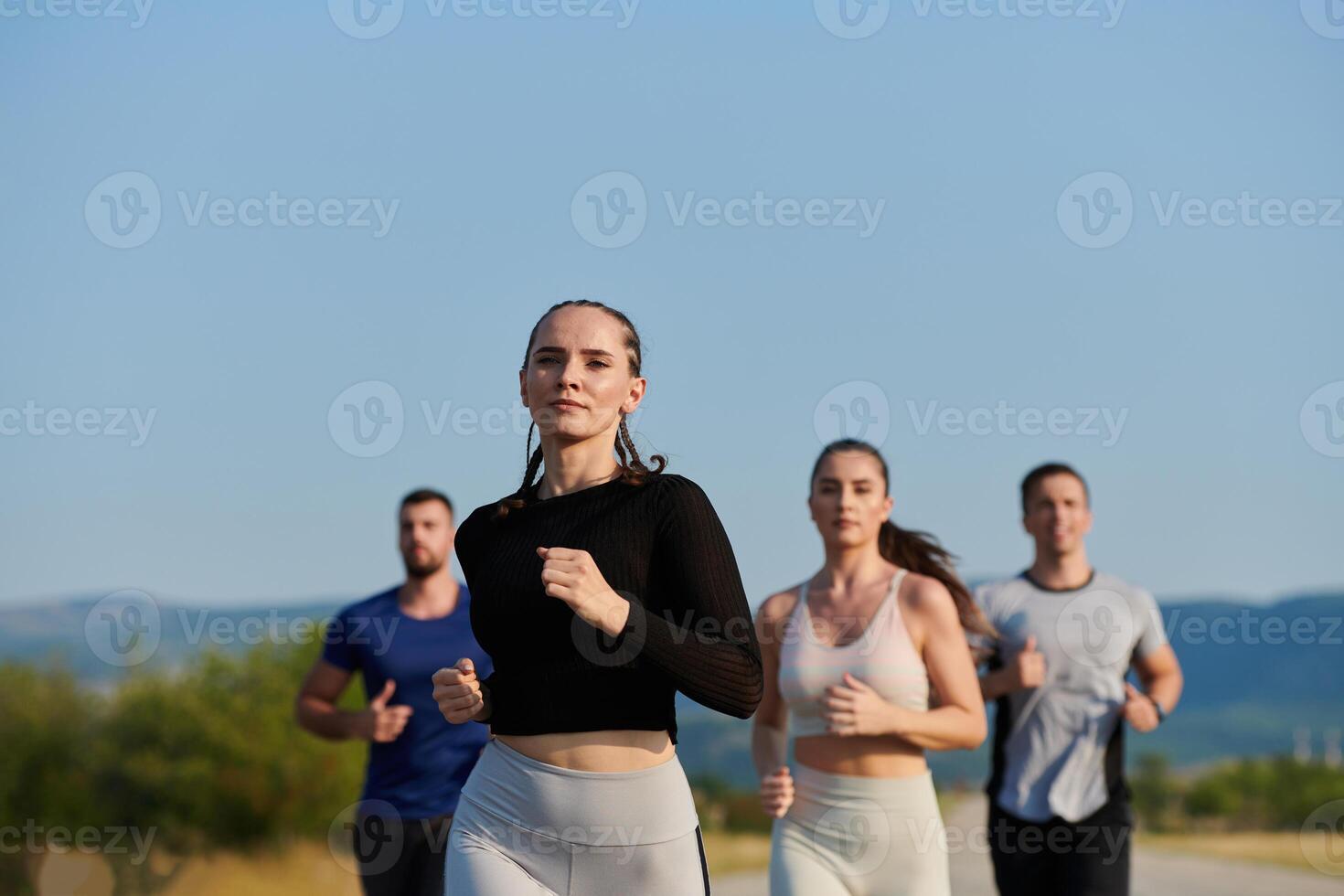A group of friends maintains a healthy lifestyle by running outdoors on a sunny day, bonding over fitness and enjoying the energizing effects of exercise and nature photo