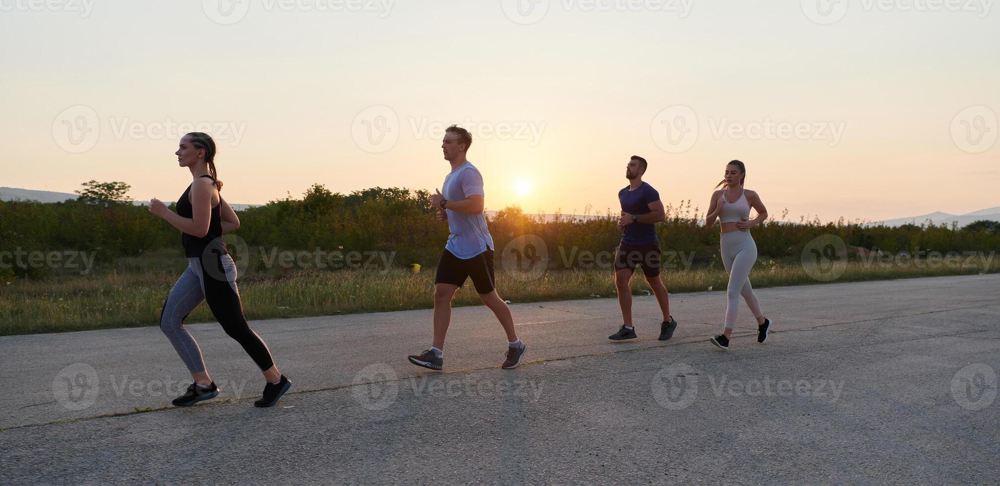 A diverse group of runners trains together at sunset. photo