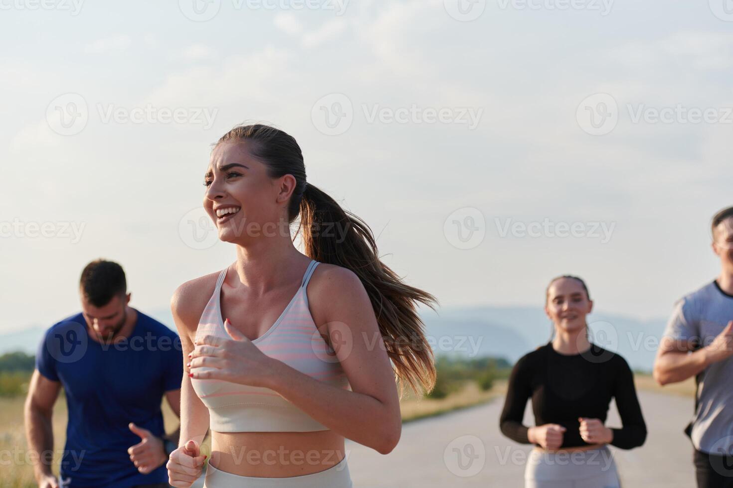 A group of friends maintains a healthy lifestyle by running outdoors on a sunny day, bonding over fitness and enjoying the energizing effects of exercise and nature photo