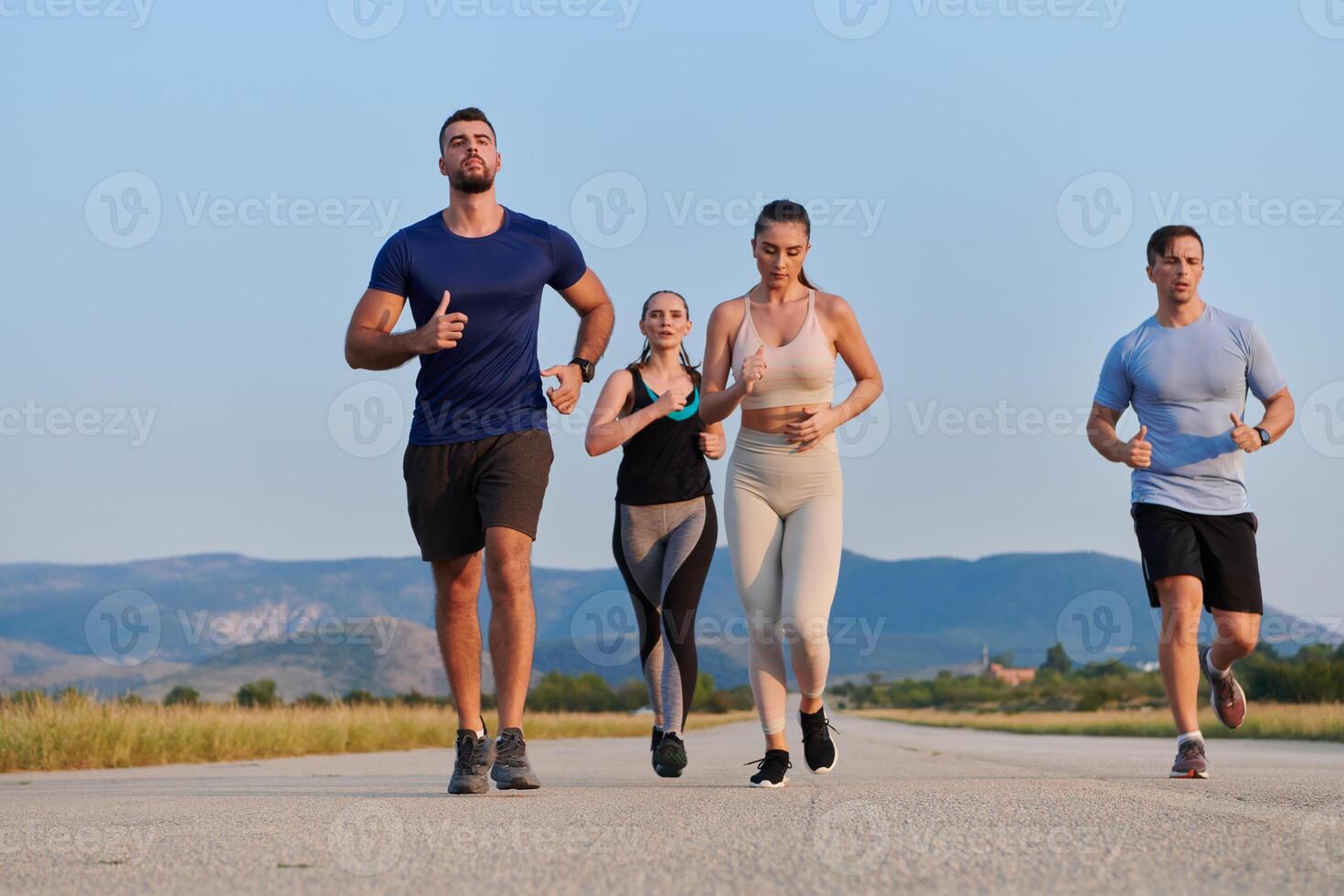 A group of friends maintains a healthy lifestyle by running outdoors on a sunny day, bonding over fitness and enjoying the energizing effects of exercise and nature photo