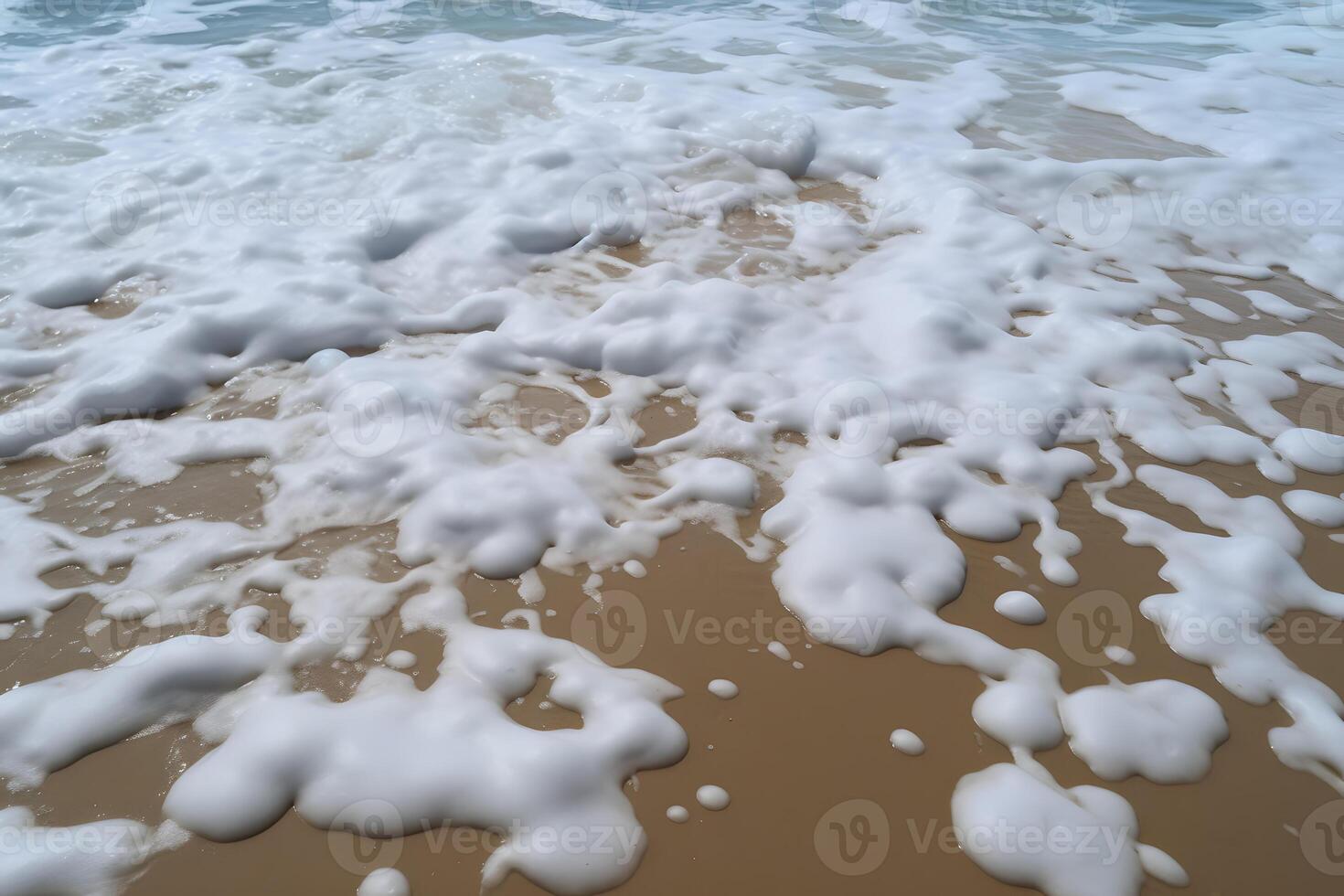Sandy beach washed by sea water with foam photo