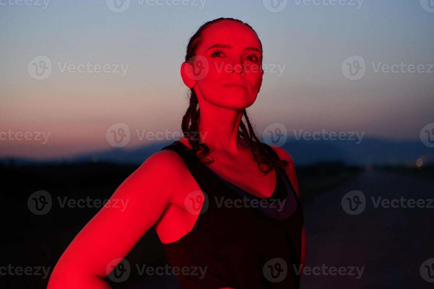 Athlete Strikes a Pose in Red-Lit Nighttime Glow photo