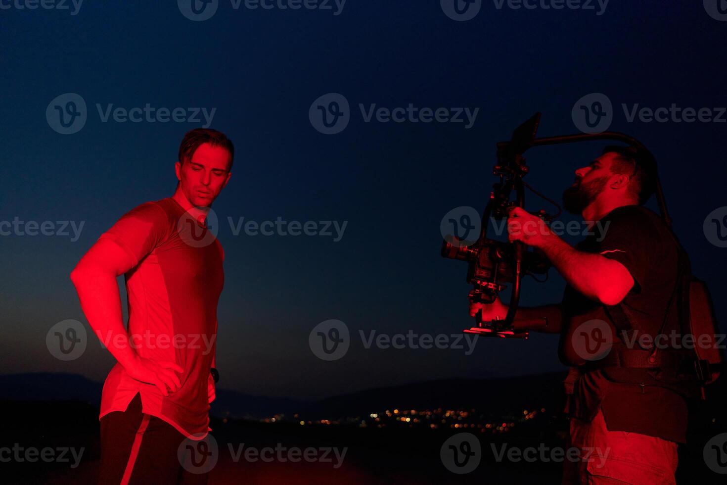 Nighttime Capture. Professional Videographer Films Athletes Running in Red-Lit Darkness photo