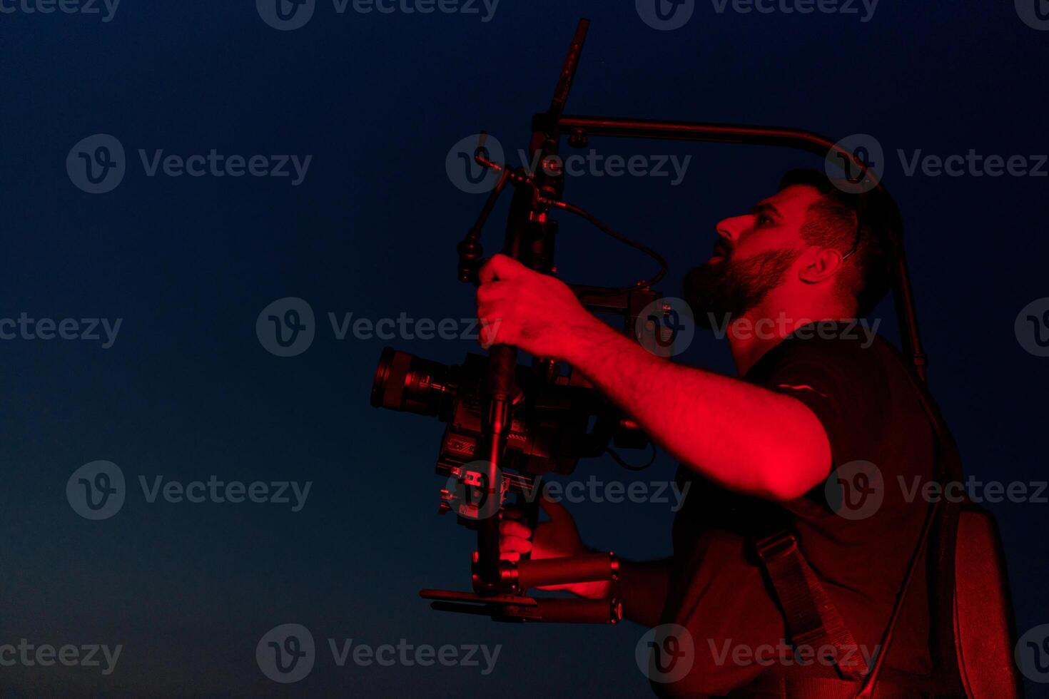 Nighttime Capture. Professional Videographer Films Athletes Running in Red-Lit Darkness photo