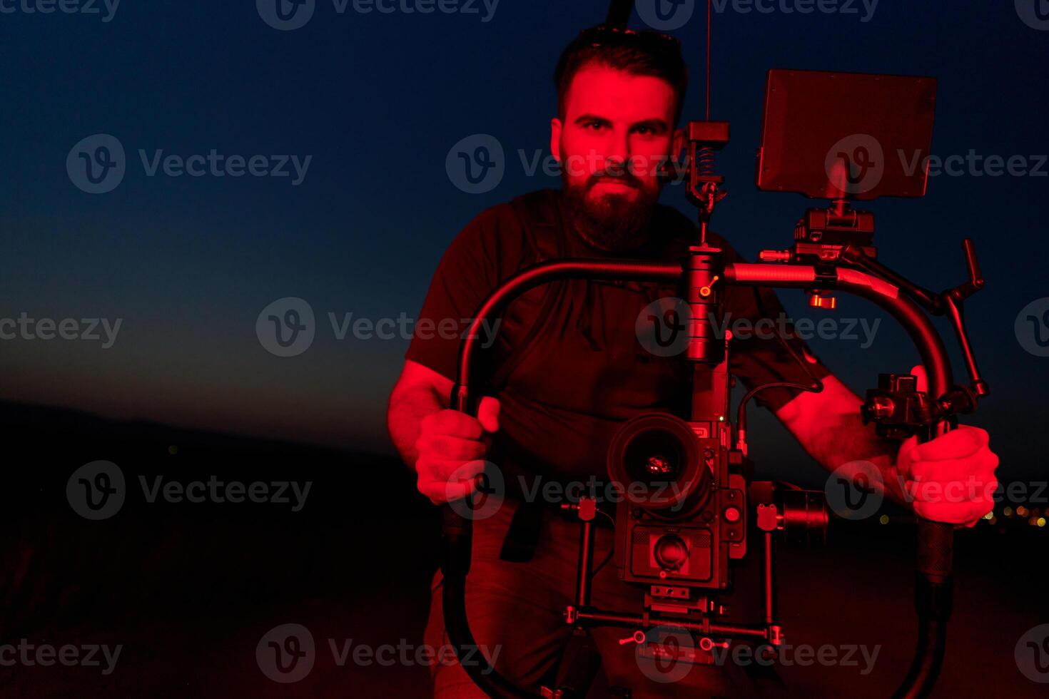 Nighttime Capture. Professional Videographer Films Athletes Running in Red-Lit Darkness photo