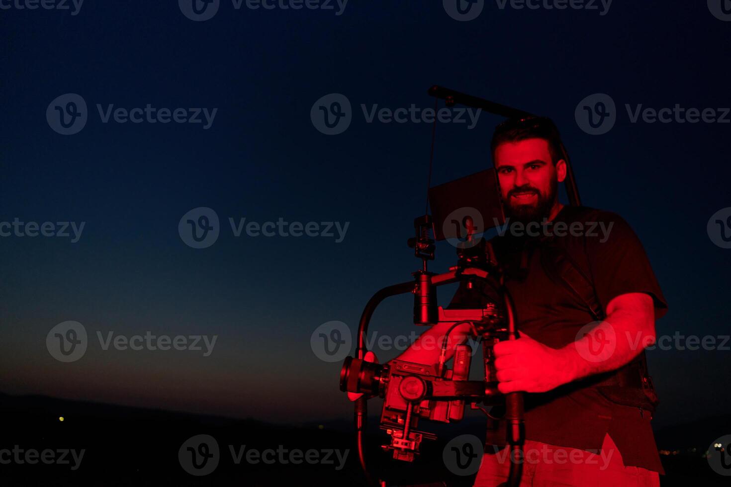 Nighttime Capture. Professional Videographer Films Athletes Running in Red-Lit Darkness photo