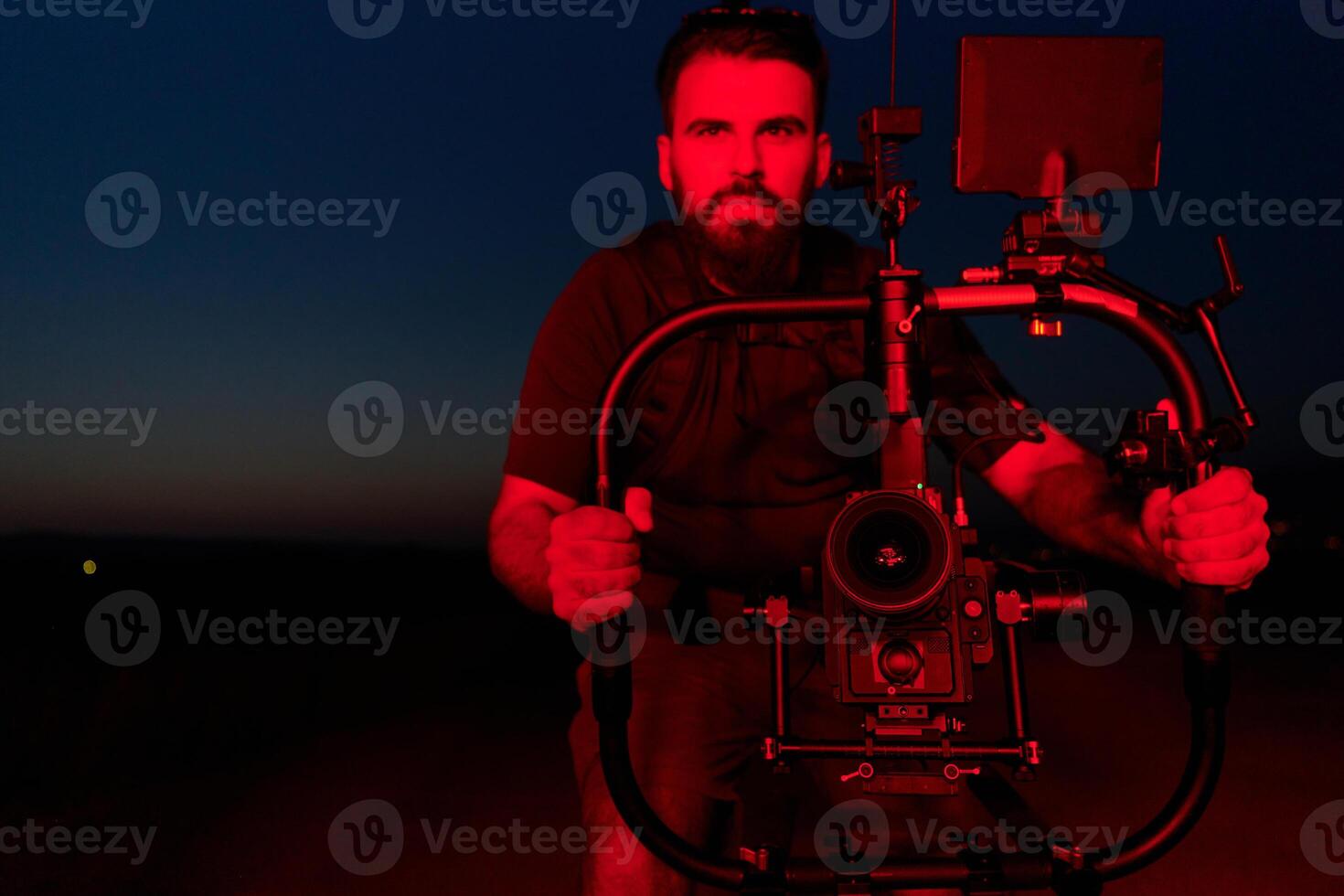 Nighttime Capture. Professional Videographer Films Athletes Running in Red-Lit Darkness photo
