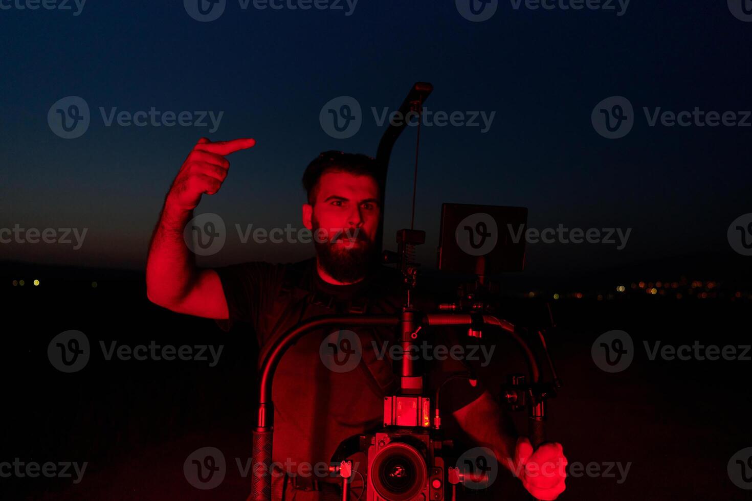 Nighttime Capture. Professional Videographer Films Athletes Running in Red-Lit Darkness photo