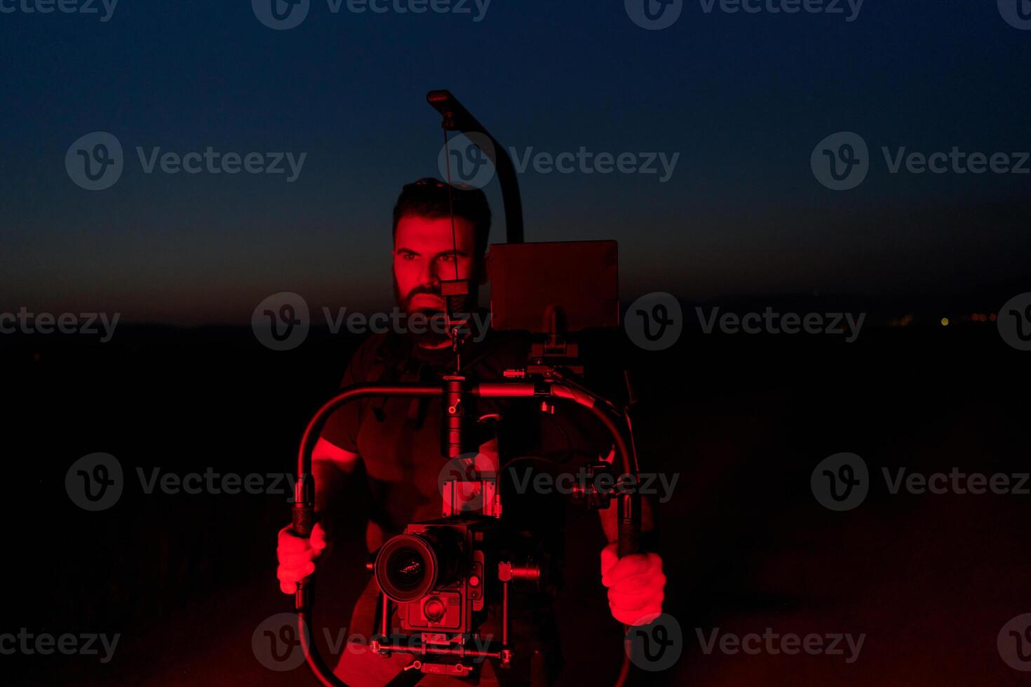 Nighttime Capture. Professional Videographer Films Athletes Running in Red-Lit Darkness photo