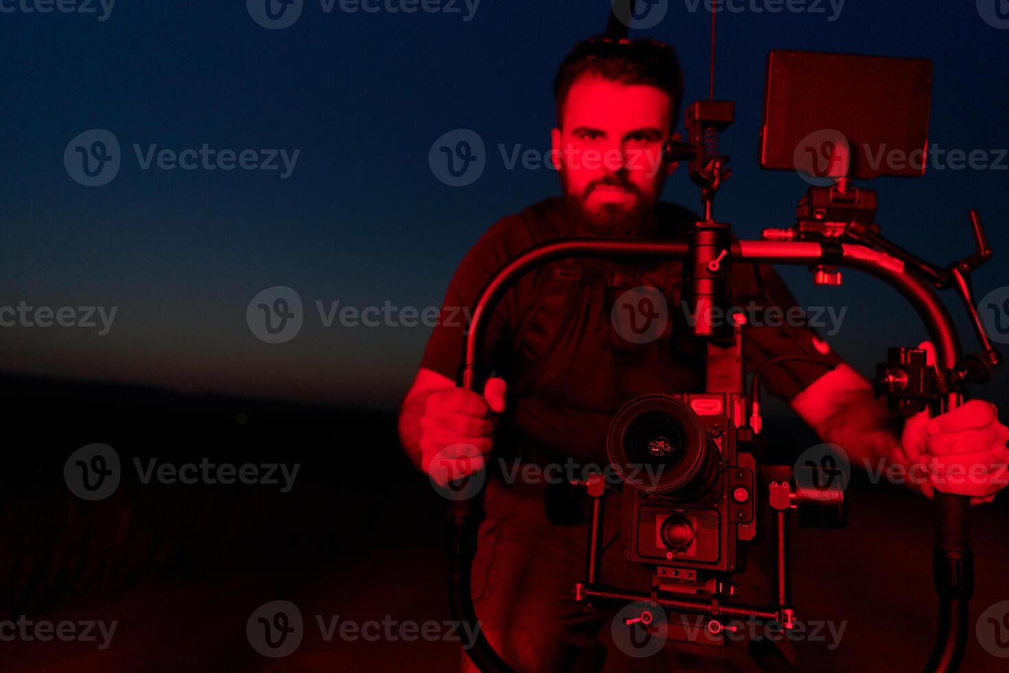 Nighttime Capture. Professional Videographer Films Athletes Running in Red-Lit Darkness photo