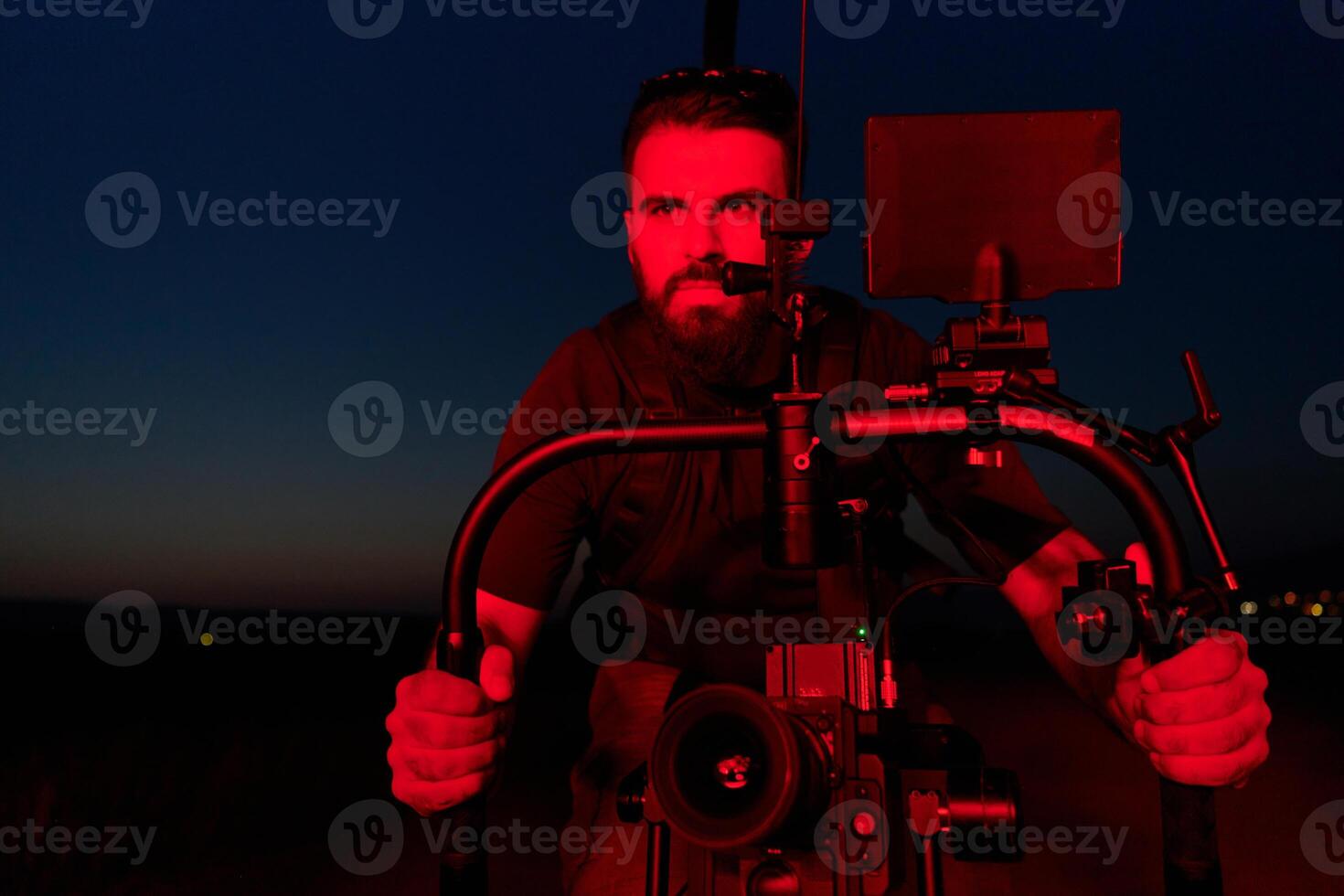 Nighttime Capture. Professional Videographer Films Athletes Running in Red-Lit Darkness photo