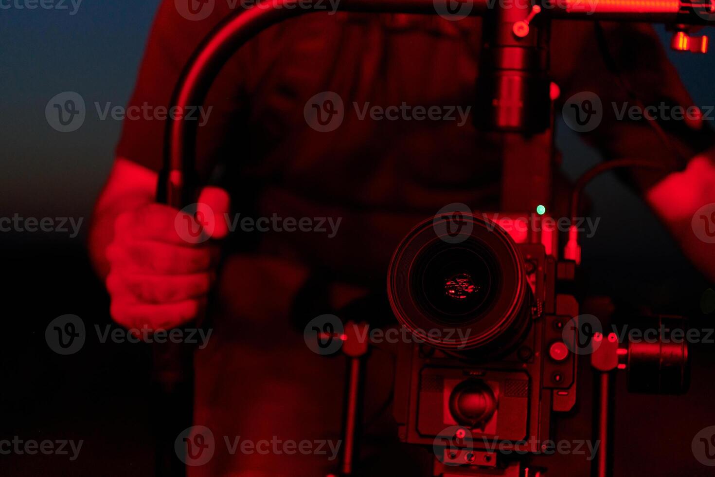 Nighttime Capture. Professional Videographer Films Athletes Running in Red-Lit Darkness photo