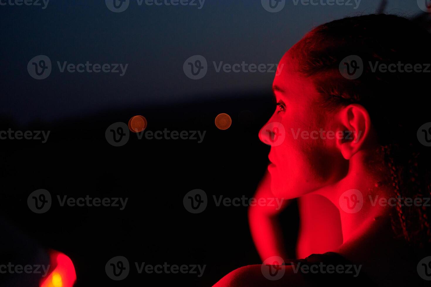 Athlete Strikes a Pose in Red-Lit Nighttime Glow photo