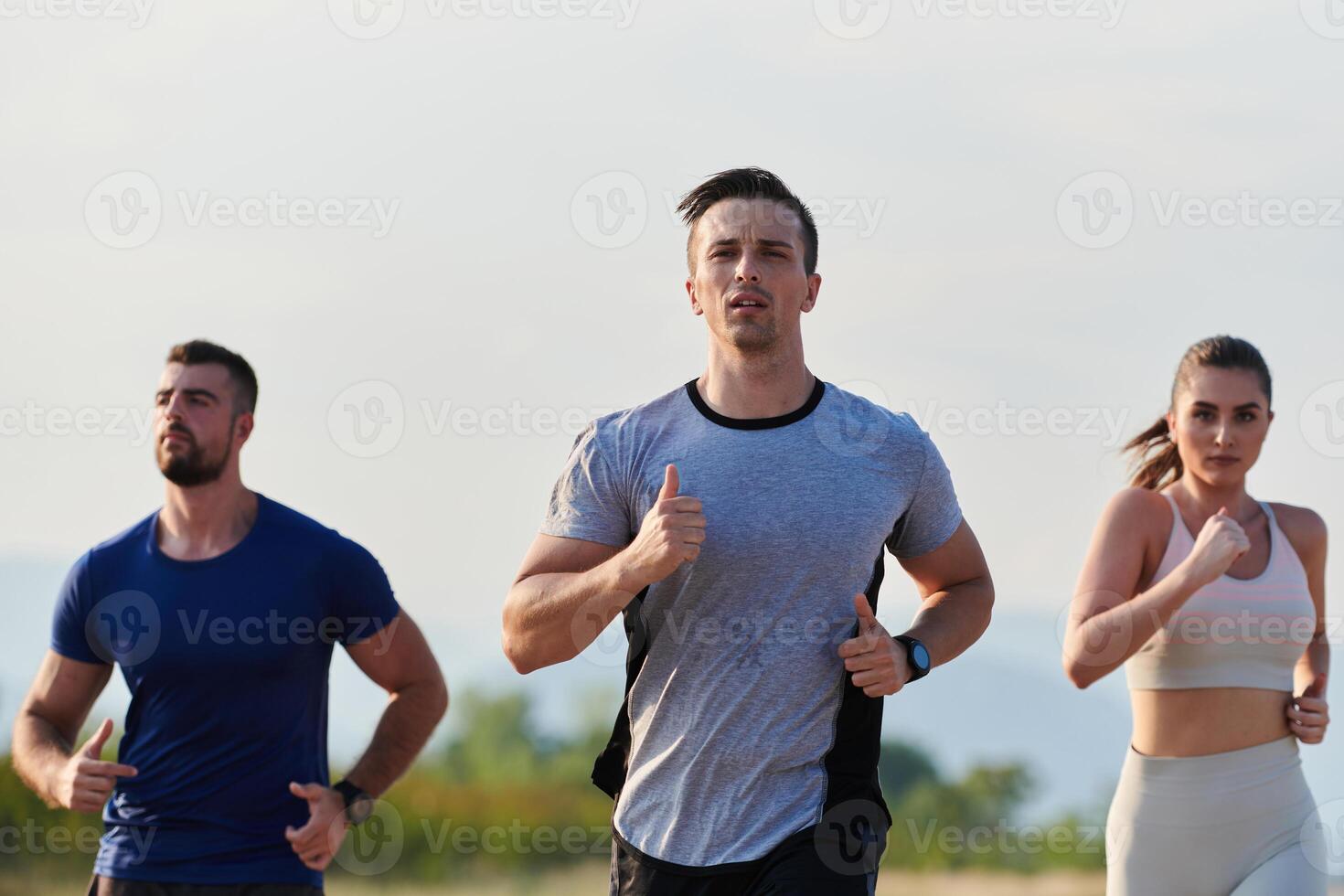 A group of friends maintains a healthy lifestyle by running outdoors on a sunny day, bonding over fitness and enjoying the energizing effects of exercise and nature photo