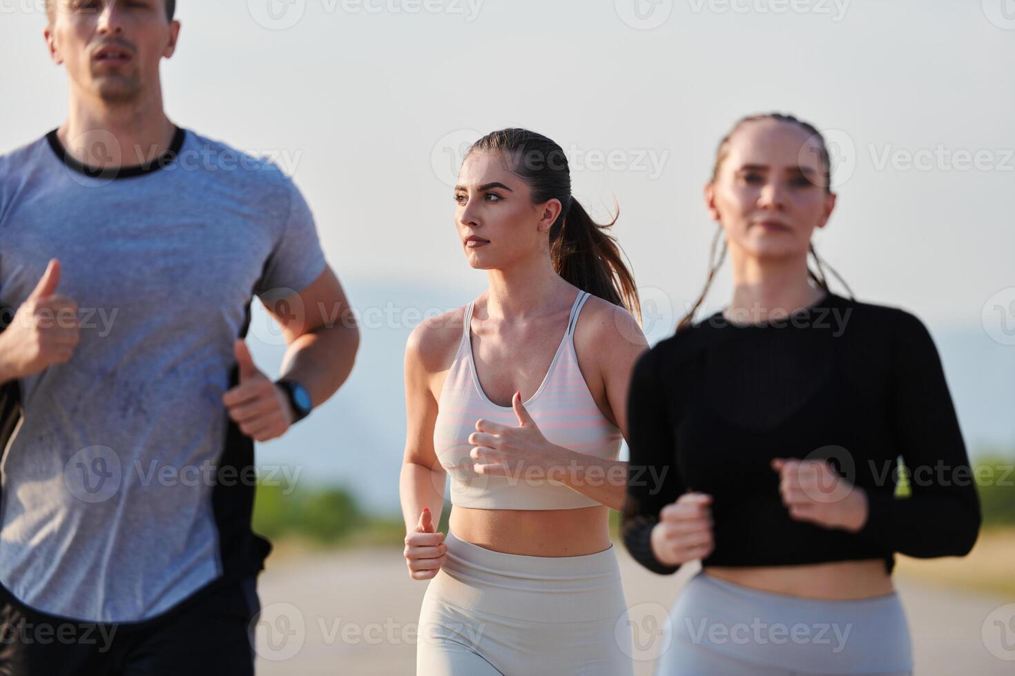A group of friends maintains a healthy lifestyle by running outdoors on a sunny day, bonding over fitness and enjoying the energizing effects of exercise and nature photo