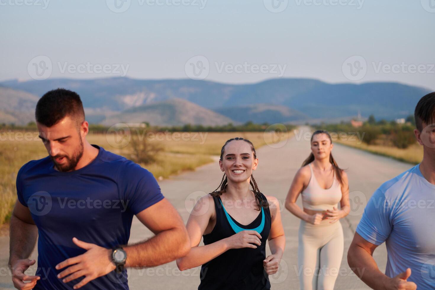A group of friends maintains a healthy lifestyle by running outdoors on a sunny day, bonding over fitness and enjoying the energizing effects of exercise and nature photo