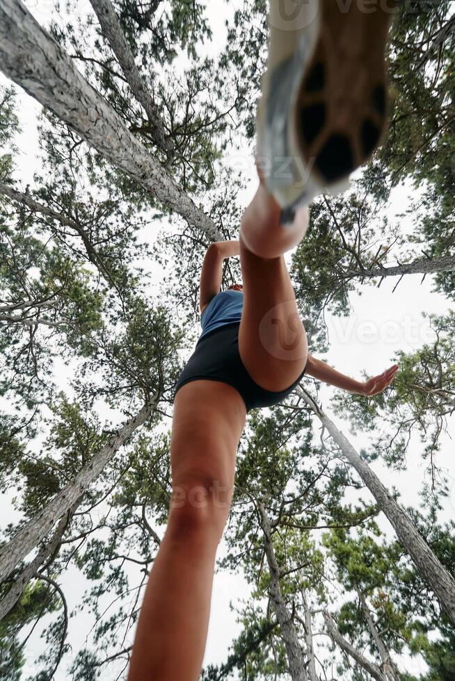 Adventurous Woman Overcoming Forest Obstacles with Determination and Agility. photo