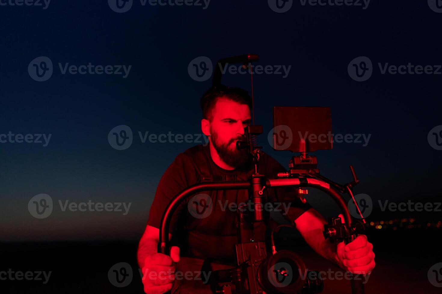 Nighttime Capture. Professional Videographer Films Athletes Running in Red-Lit Darkness photo