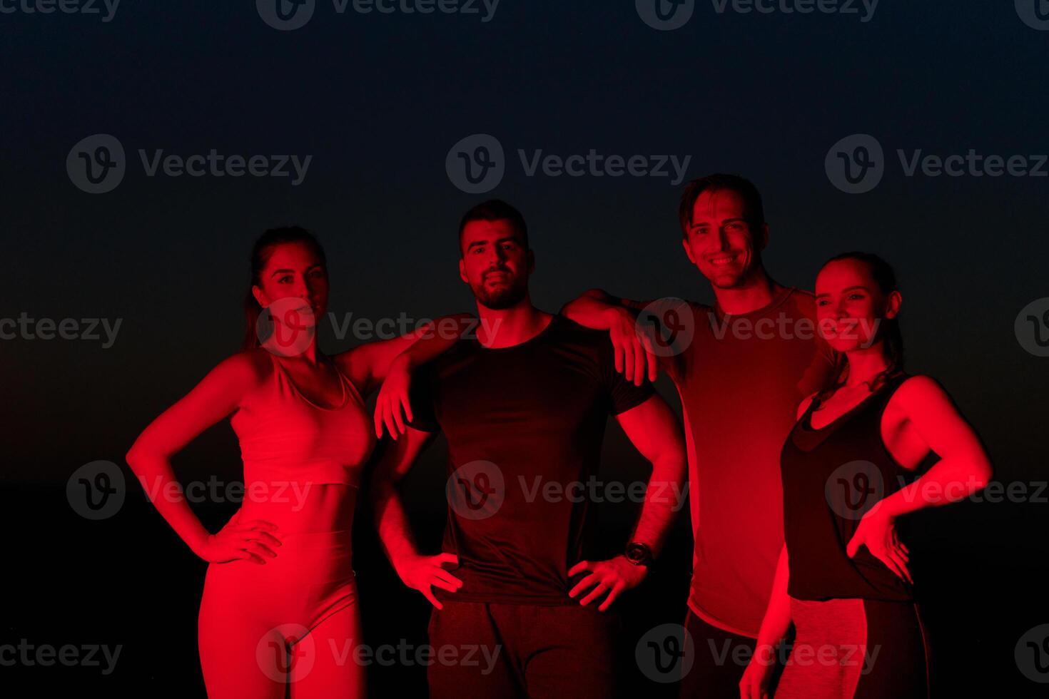 Diverse Athletes Unwind. Post-Marathon Rest Under Red Nighttime Glow. photo