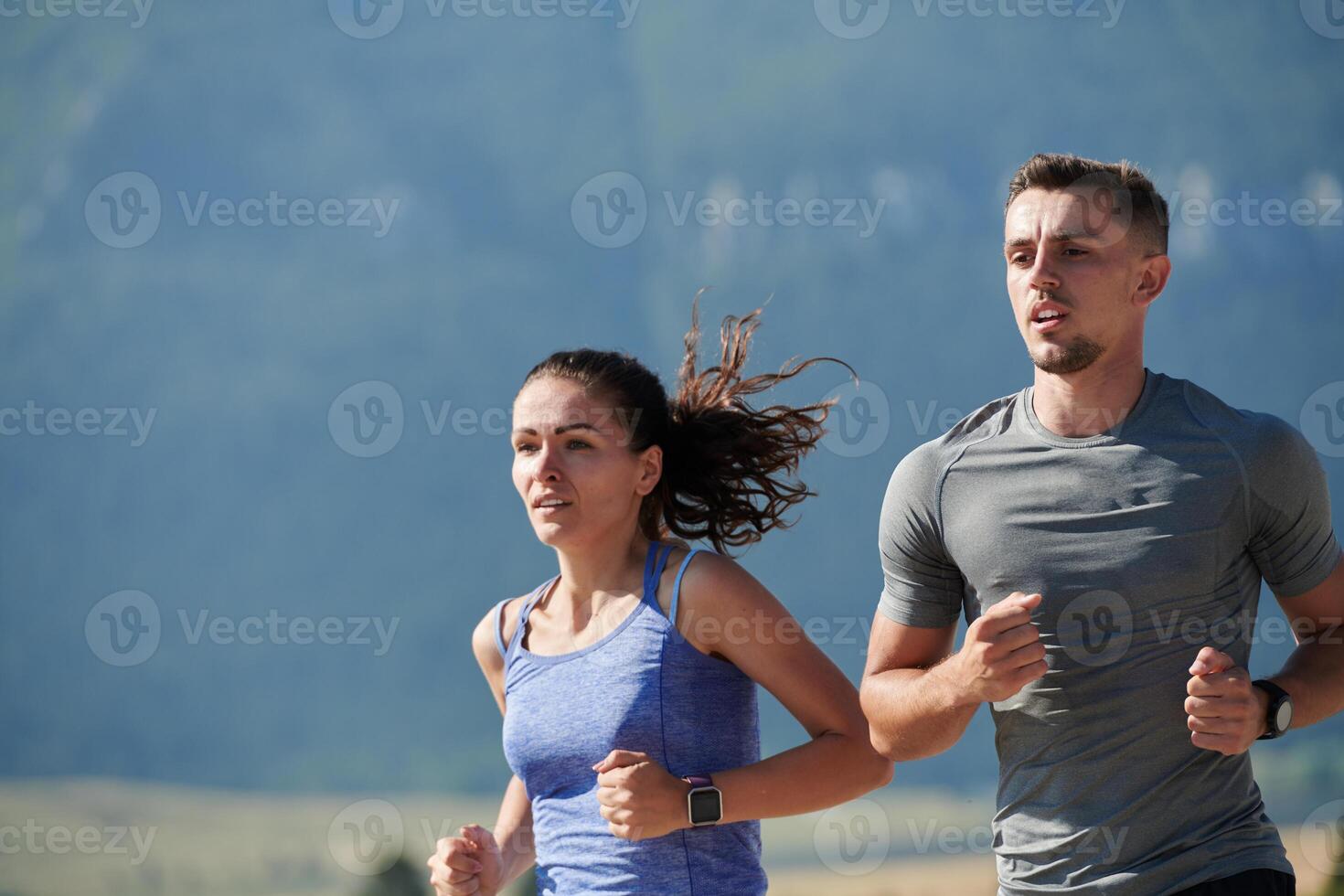 Energized by the beauty of nature, a couple powers through their morning run, their bodies and spirits invigorated. photo