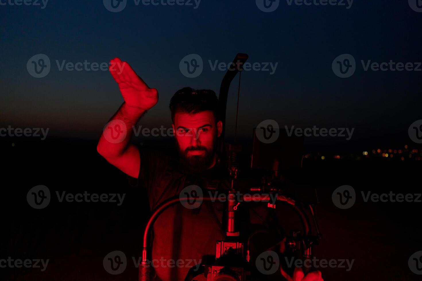 Nighttime Capture. Professional Videographer Films Athletes Running in Red-Lit Darkness photo