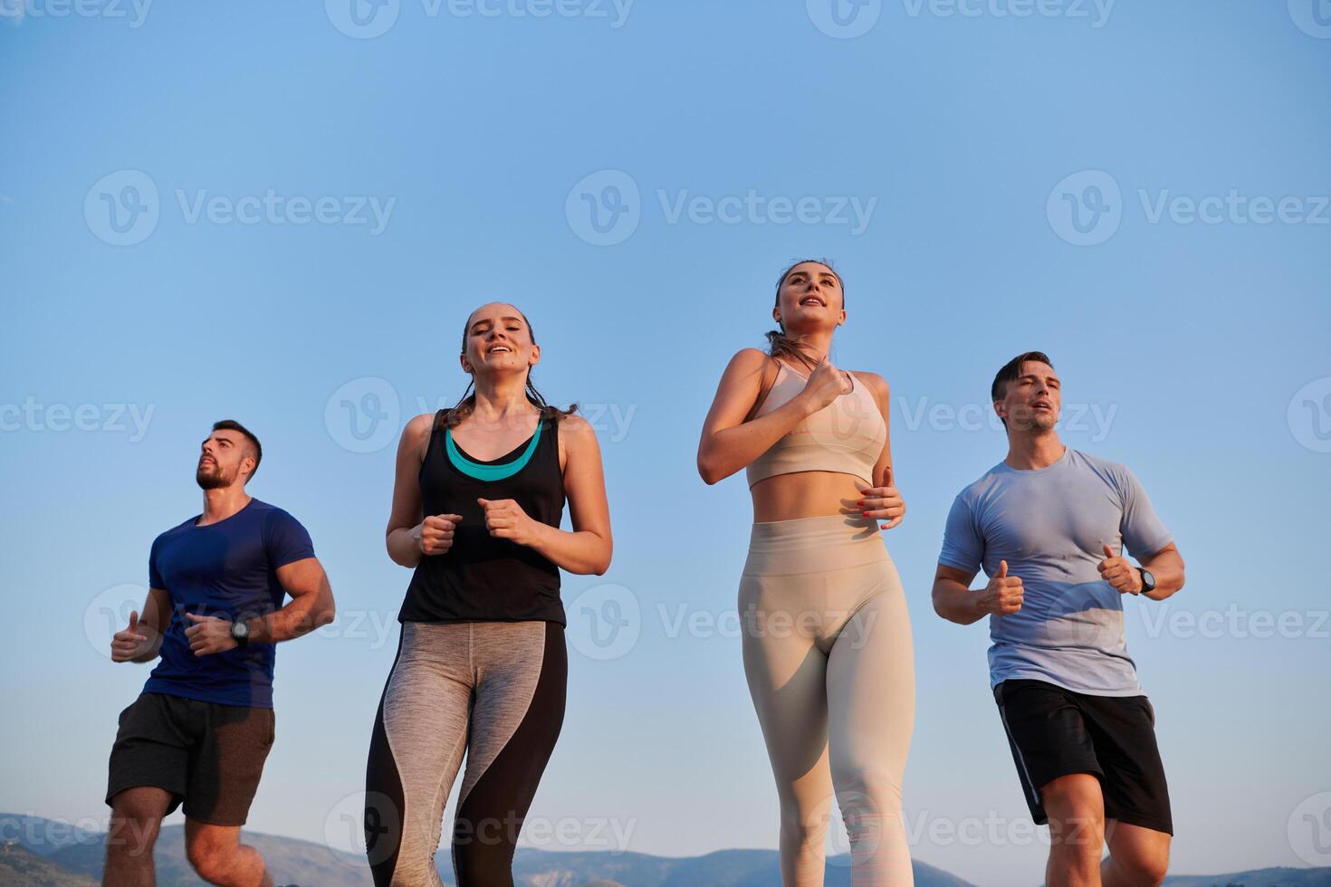 A group of friends maintains a healthy lifestyle by running outdoors on a sunny day, bonding over fitness and enjoying the energizing effects of exercise and nature photo