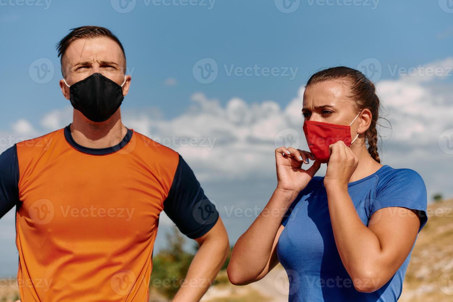 Couple running in nature at morning wearing protective face masks photo